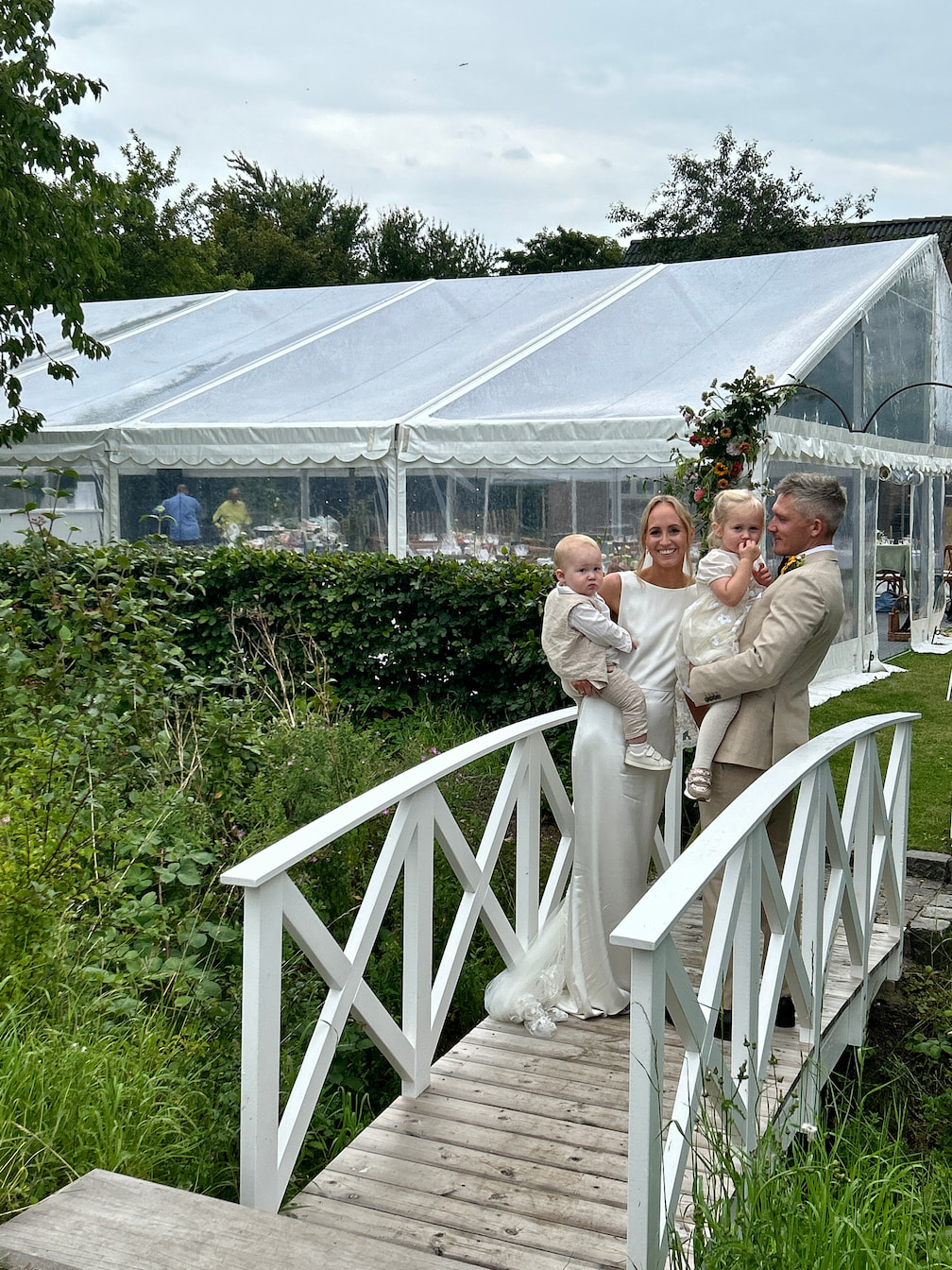 Havebryllup med gæster ved bro og telt